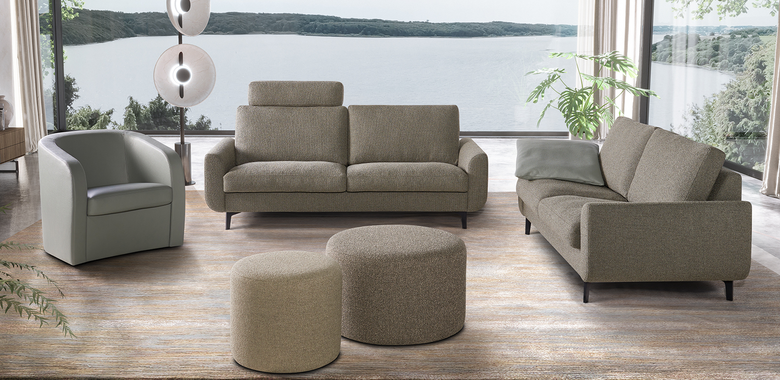 Two CL830 sofas in grey-brown fabric with round stools and matching armchair in grey leather in modern living room with lake view